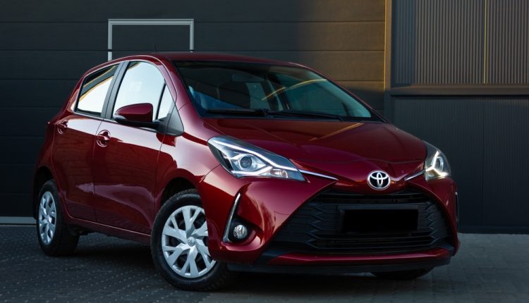 Toyota,Yaris,Hybrid,,On,The,Background,Of,A,Beautiful,Wall.